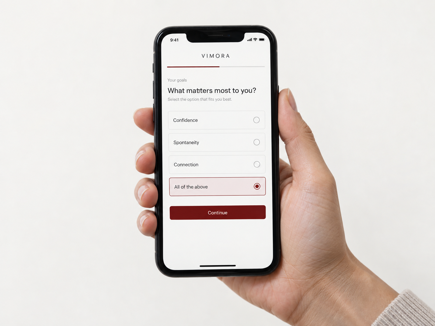 A hand holding a phone displaying the Vimora goals questionnaire